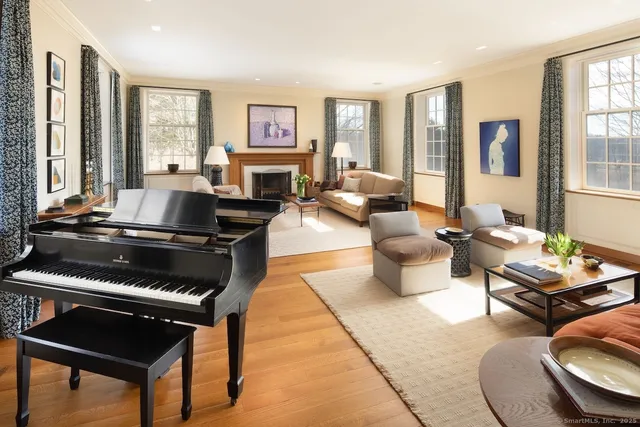 a living room with furniture fireplace and a large window