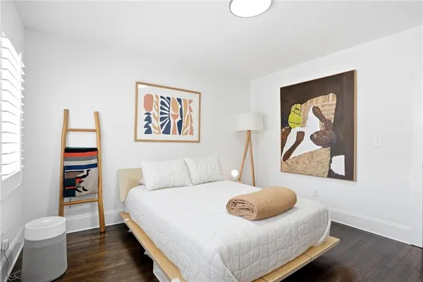 a bedroom with a bed and a painting on the wall