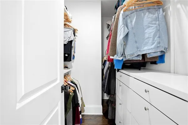 a view of walk in closet with clothes and shoes