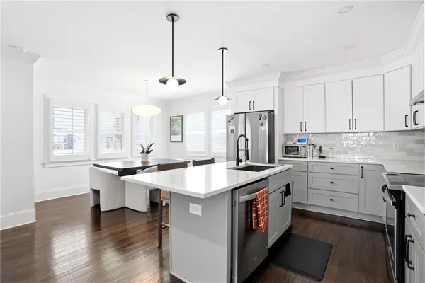 a kitchen that has a lot of cabinets in it and wooden floors