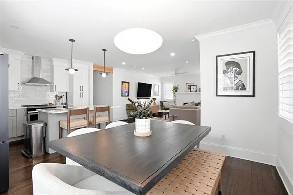 a kitchen with stainless steel appliances granite countertop a sink dishwasher and a refrigerator with wooden floor