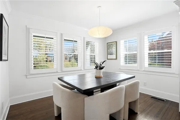 a kitchen with a table chairs and wooden floor
