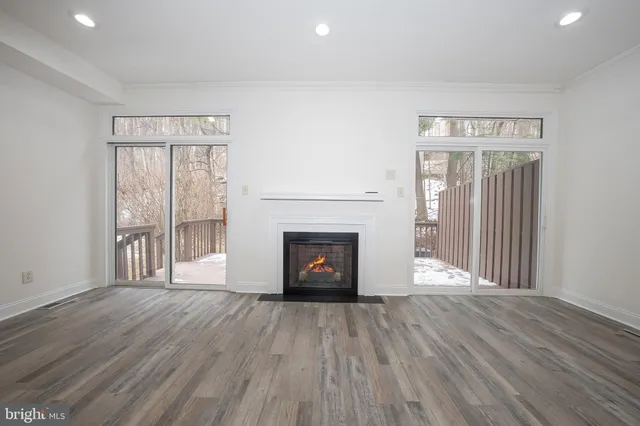 an empty room with wooden floor and fireplace