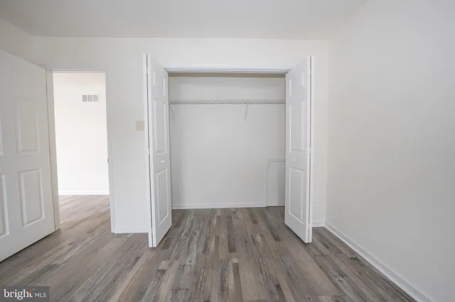 an empty room with a window and wooden floor
