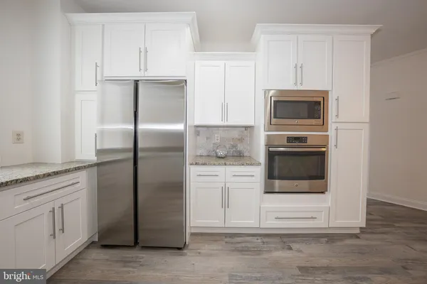 a kitchen with white cabinets and stainless steel appliances