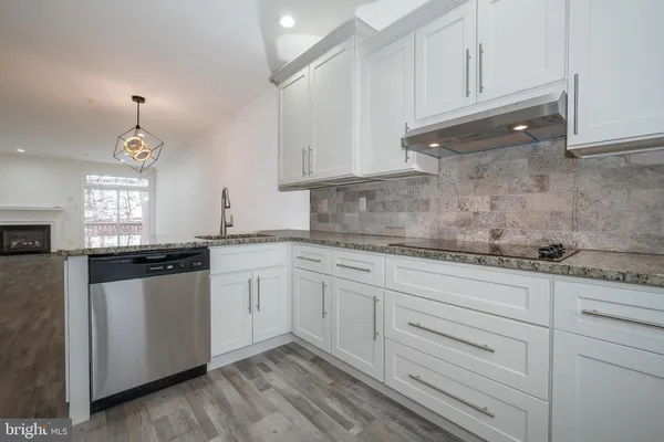 a kitchen with granite countertop white cabinets and white appliances
