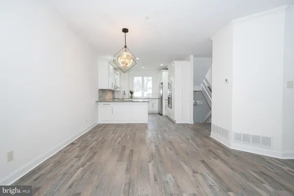 a view of empty room with wooden floor and window