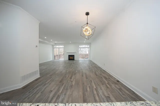 a view of empty room with wooden floor and window