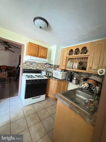 a kitchen with granite countertop a stove top oven a sink and cabinets