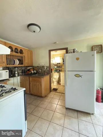 a kitchen with a refrigerator a stove top oven and cabinets