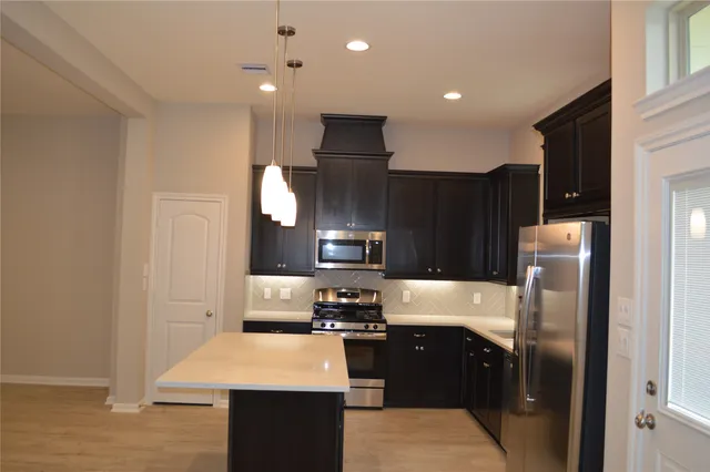 a kitchen with a refrigerator and a stove