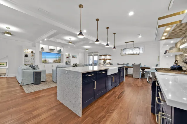 a large kitchen with stainless steel appliances lots of counter space a sink and a wooden floor