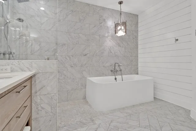 a white bath tub sitting in a bathroom and shower