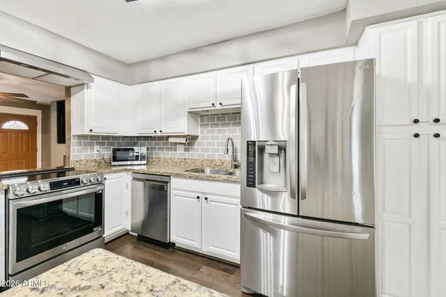 a kitchen with stainless steel appliances a refrigerator sink and cabinets