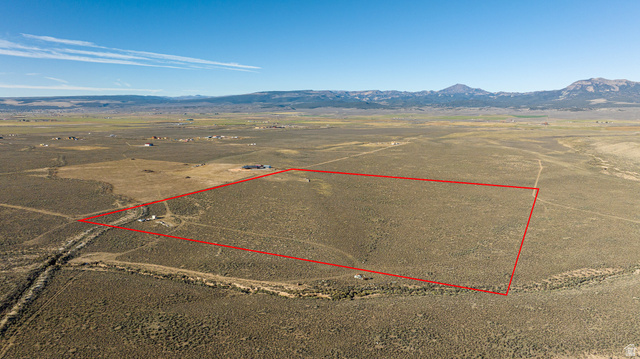 2455 East Cale Road Panguitch, UT 84759 - Photo 2 of 12 Aerial view of sparsely populated area with property boundaries highlighted and a mountainous background