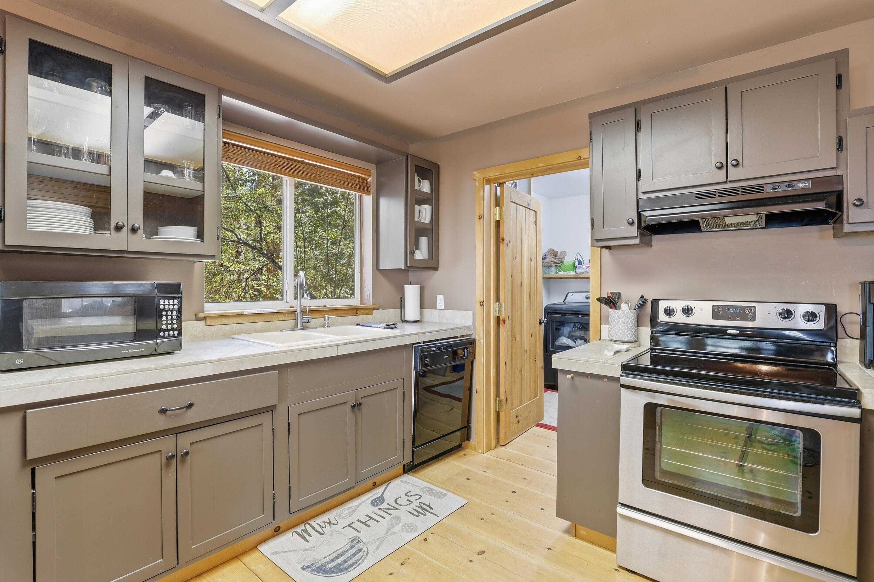 6322 Sharyn Road Pine, AZ 85544 - Photo 13 of 37 a kitchen with stainless steel appliances wooden floor sink and wooden cabinets