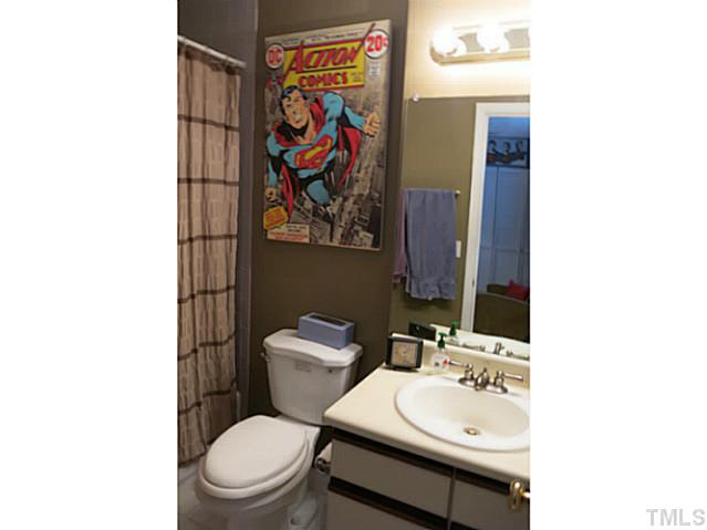 2403 Condor Court, Unit 2403 Raleigh, NC 27615 - Photo 16 of 25 a bathroom with a toilet a sink and mirror