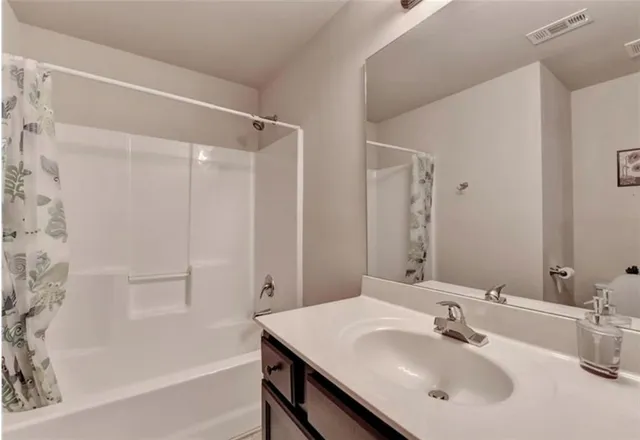 a bathroom with a sink mirror and a bathtub