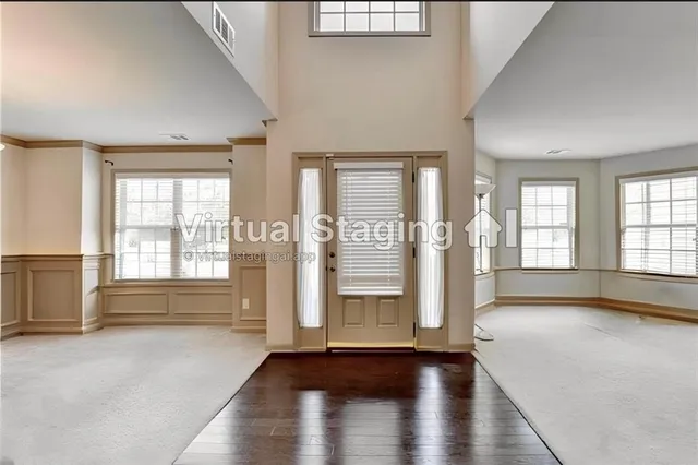 a view of an empty room with window and wooden floor