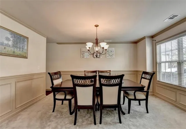a view of a dining room with furniture and chandelier