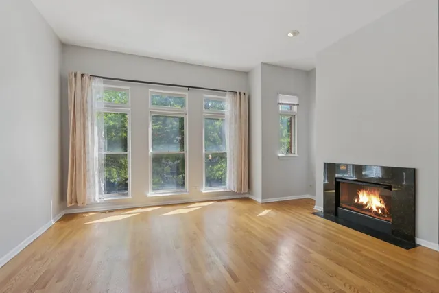 a view of an empty room with a fireplace and a window