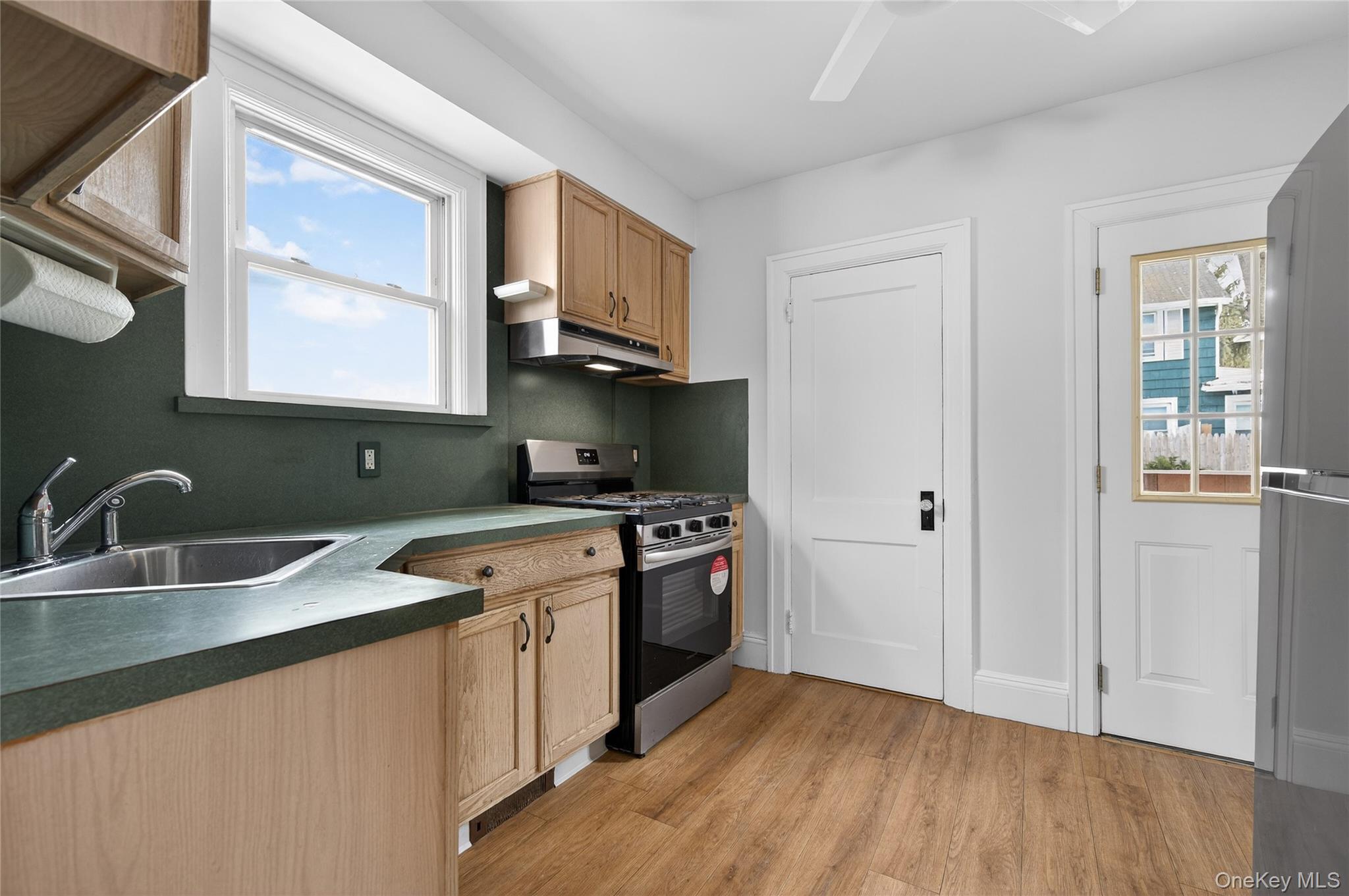 26 West 5th Street Locust Valley, NY 11560 - Photo 11 of 36 a kitchen with stainless steel appliances granite countertop a sink stove and refrigerator