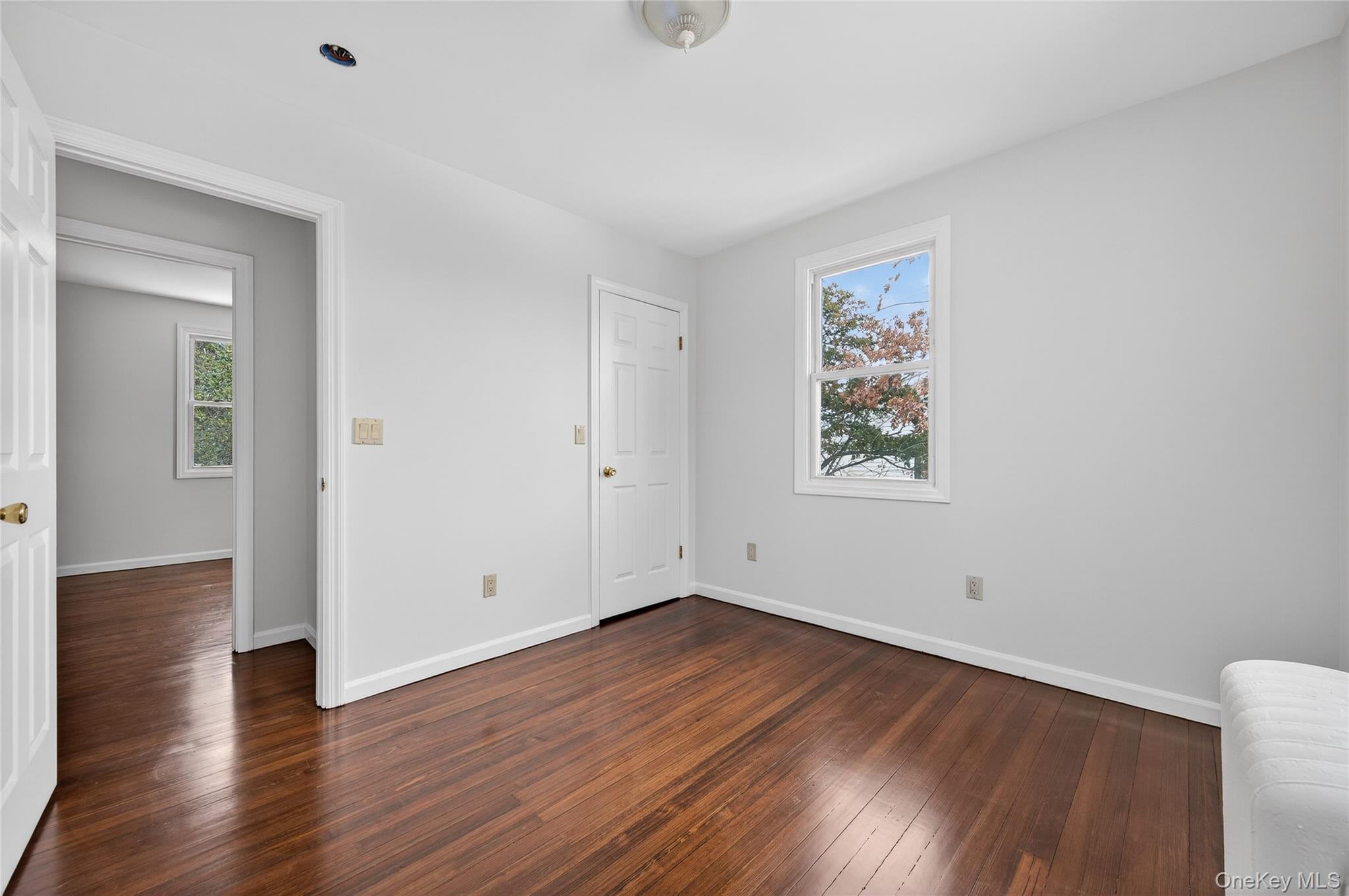 26 West 5th Street Locust Valley, NY 11560 - Photo 17 of 36 a view of an empty room with wooden floor and windows