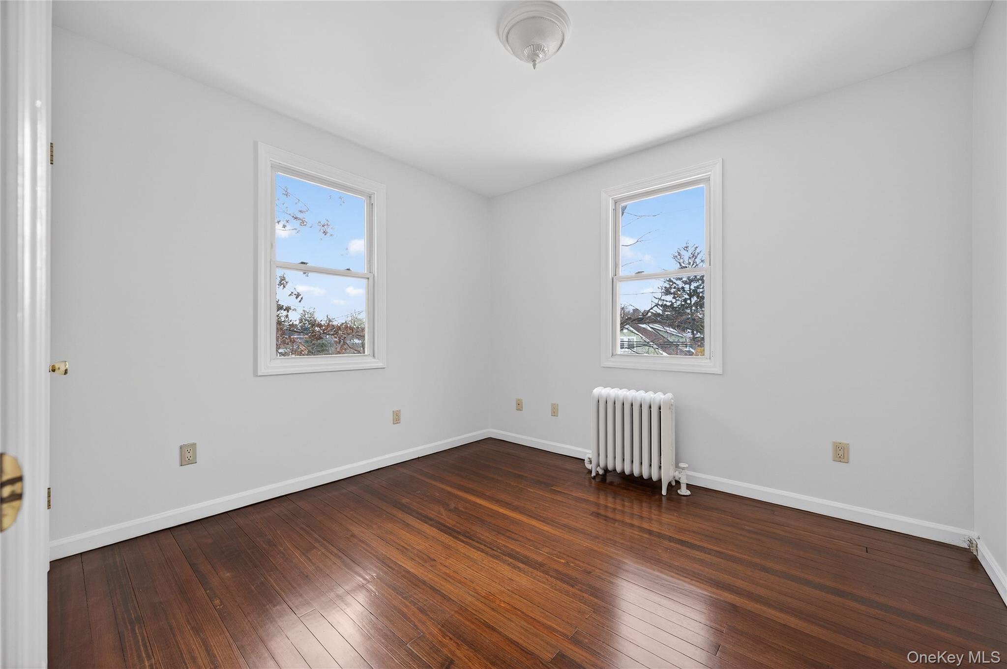 26 West 5th Street Locust Valley, NY 11560 - Photo 18 of 36 an empty room with wooden floor and windows