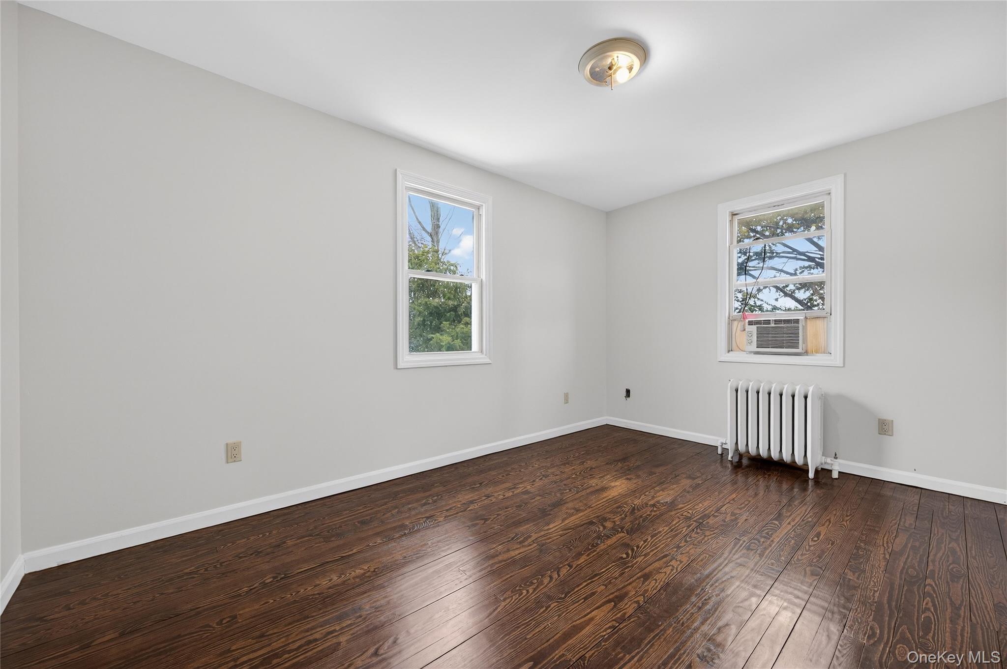 26 West 5th Street Locust Valley, NY 11560 - Photo 19 of 36 an empty room with wooden floor and windows