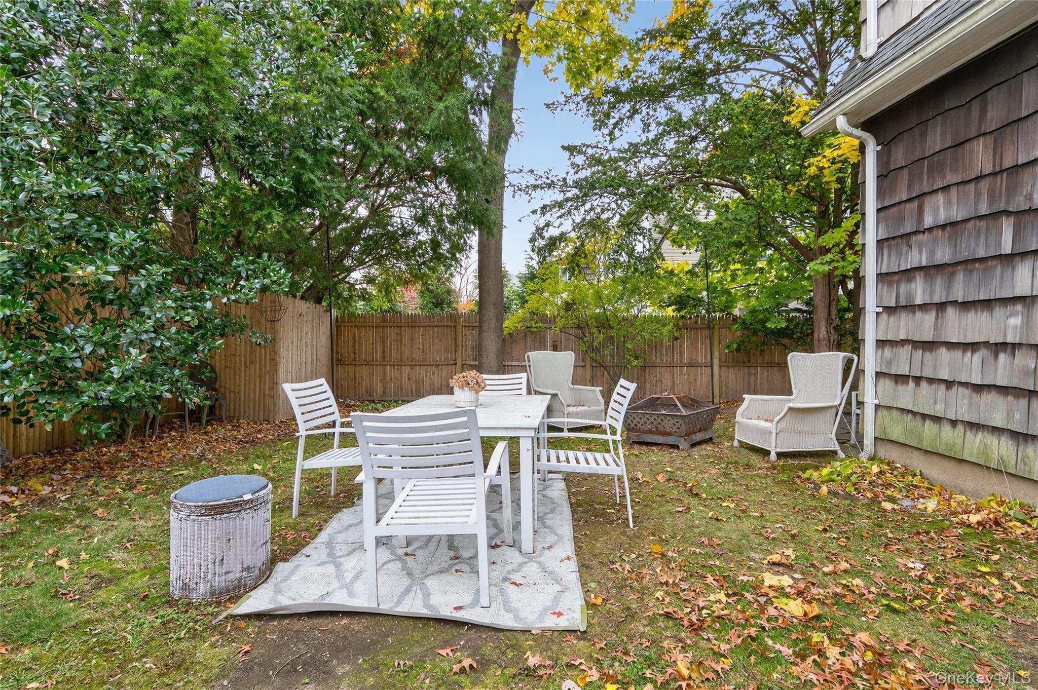 26 West 5th Street Locust Valley, NY 11560 - Photo 20 of 36 a view of a patio with table and chairs potted plants and large tree