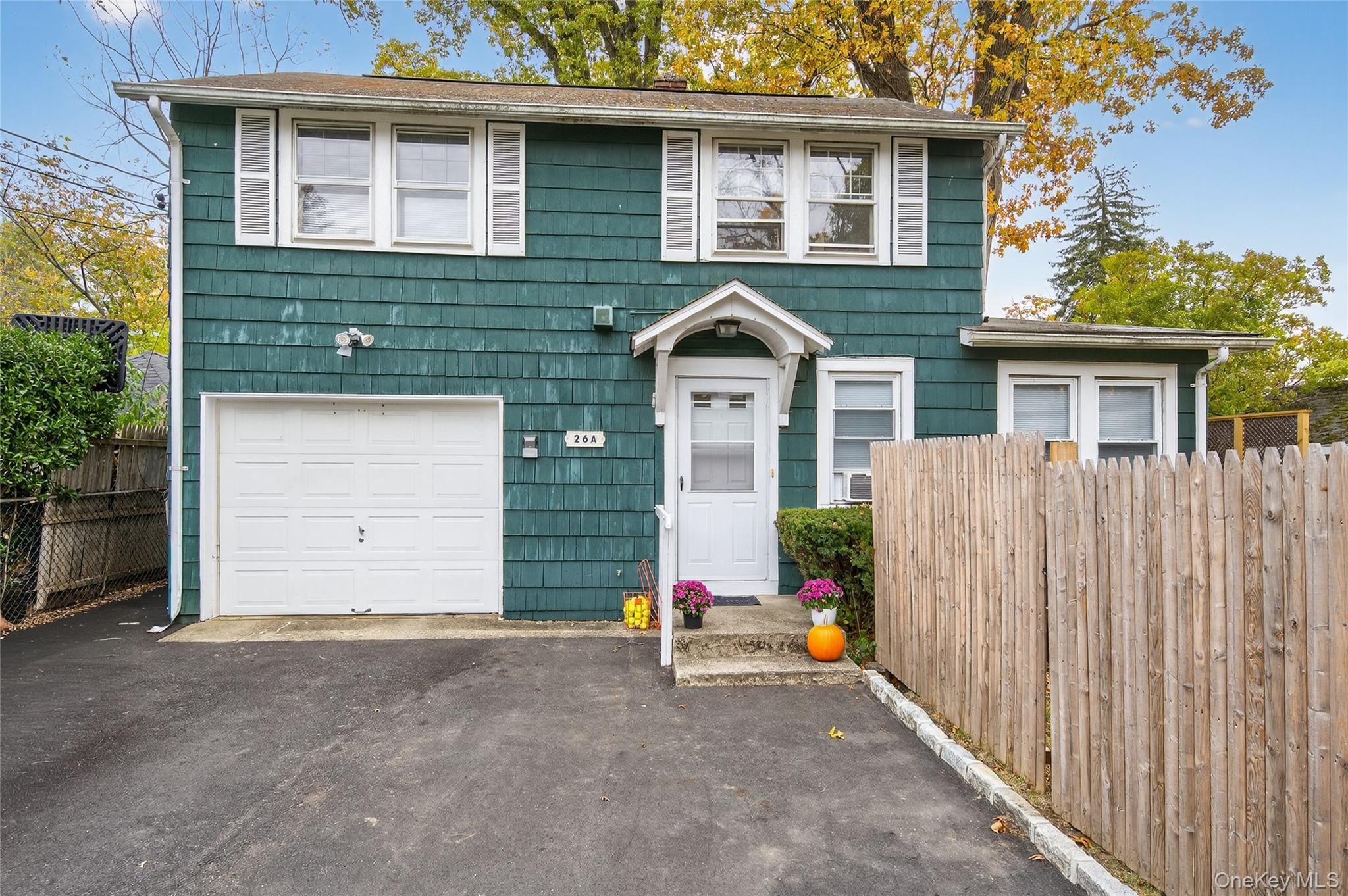 26 West 5th Street Locust Valley, NY 11560 - Photo 22 of 36 a view of a house with a small yard and wooden fence