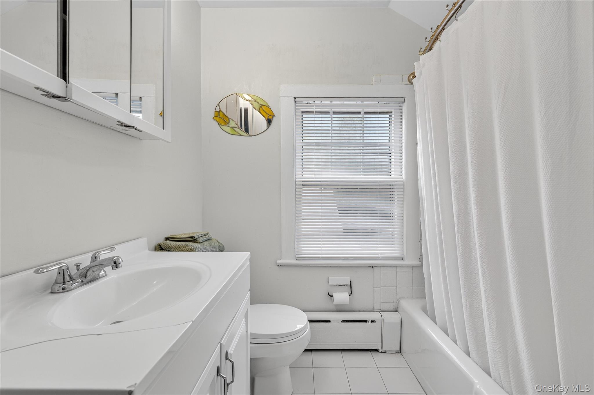 26 West 5th Street Locust Valley, NY 11560 - Photo 28 of 36 a bathroom with a sink a toilet and a window