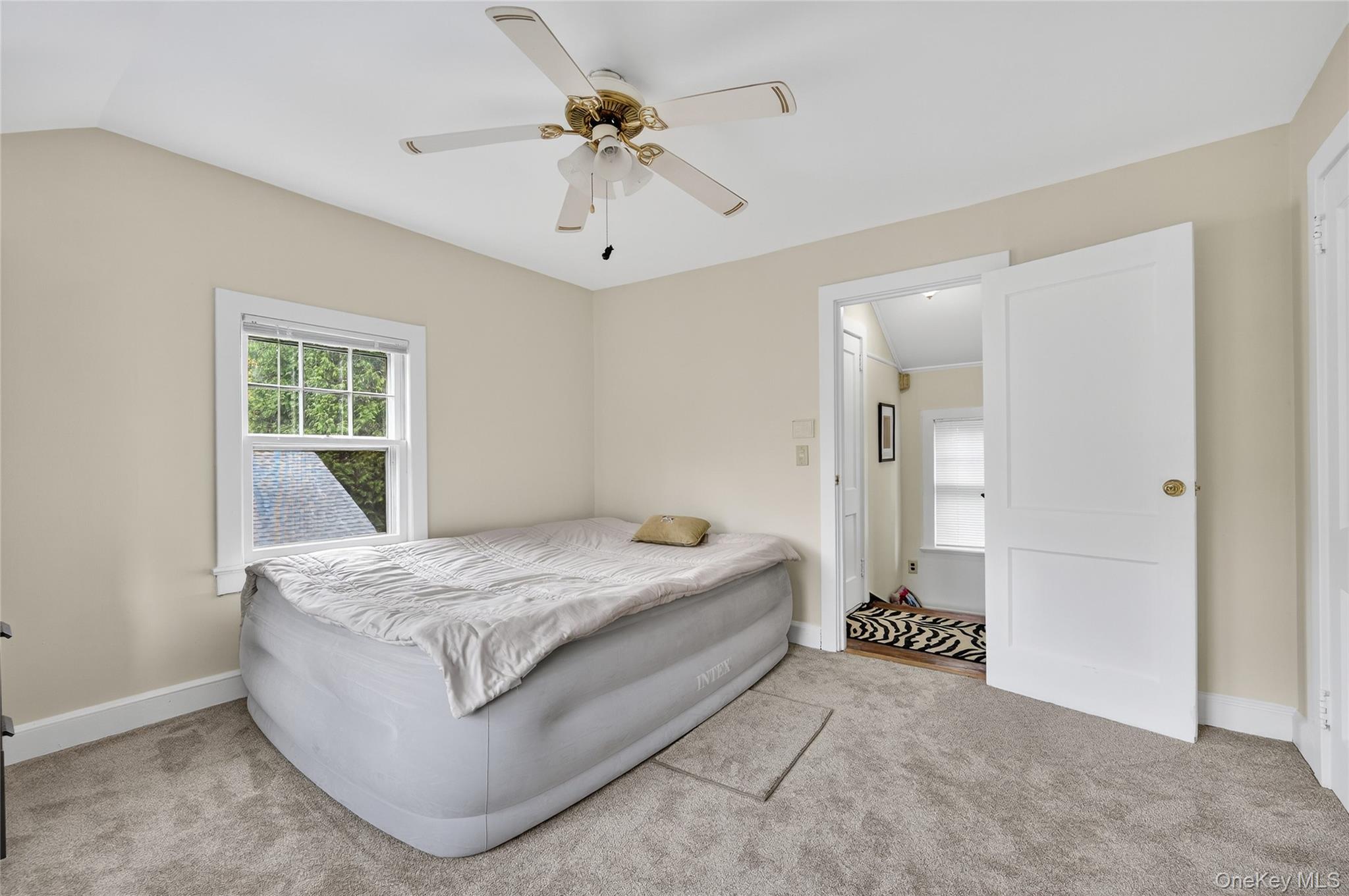 26 West 5th Street Locust Valley, NY 11560 - Photo 31 of 36 a spacious bedroom with a bed and ceiling fan