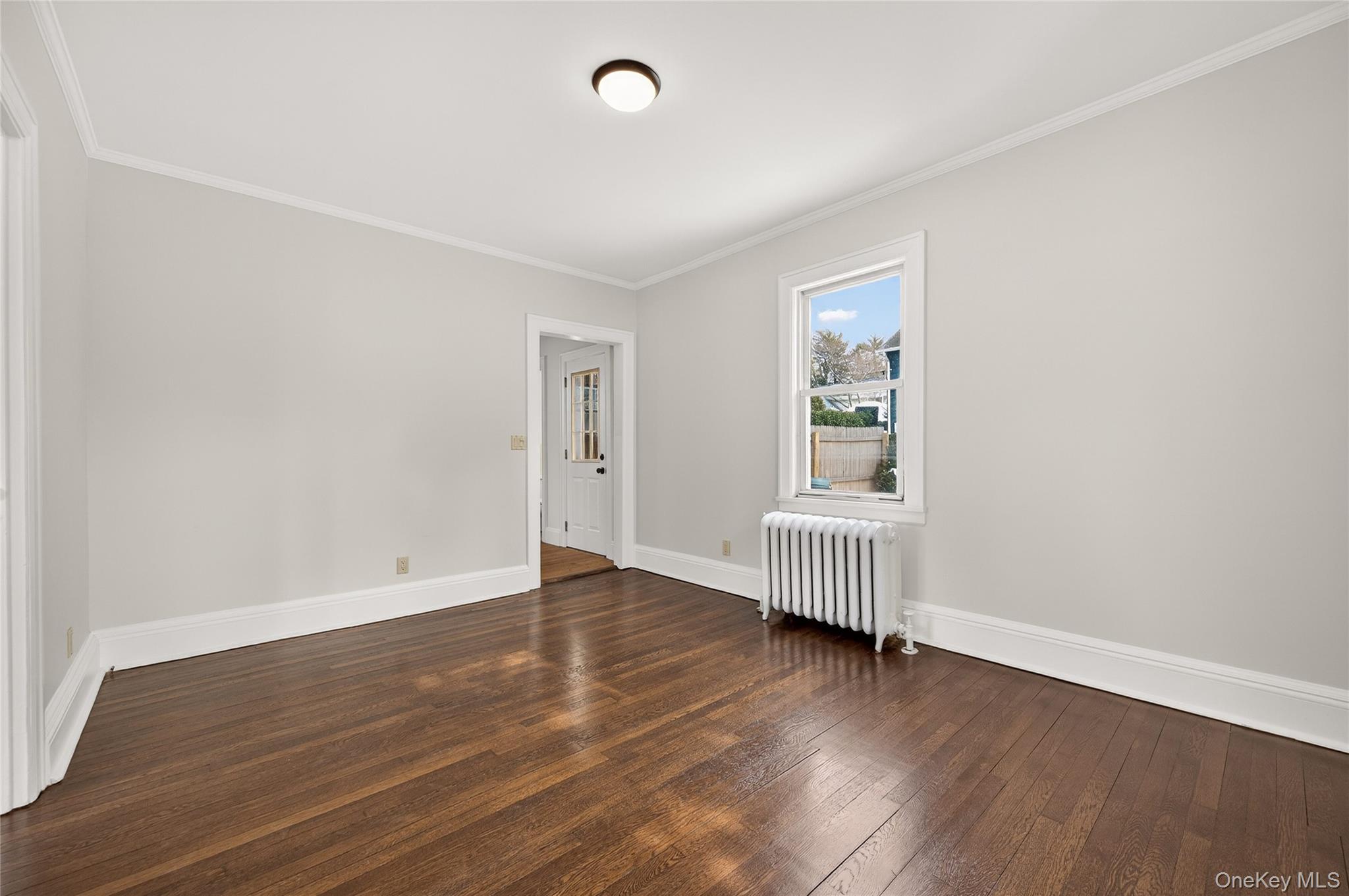26 West 5th Street Locust Valley, NY 11560 - Photo 8 of 36 an empty room with wooden floor and window