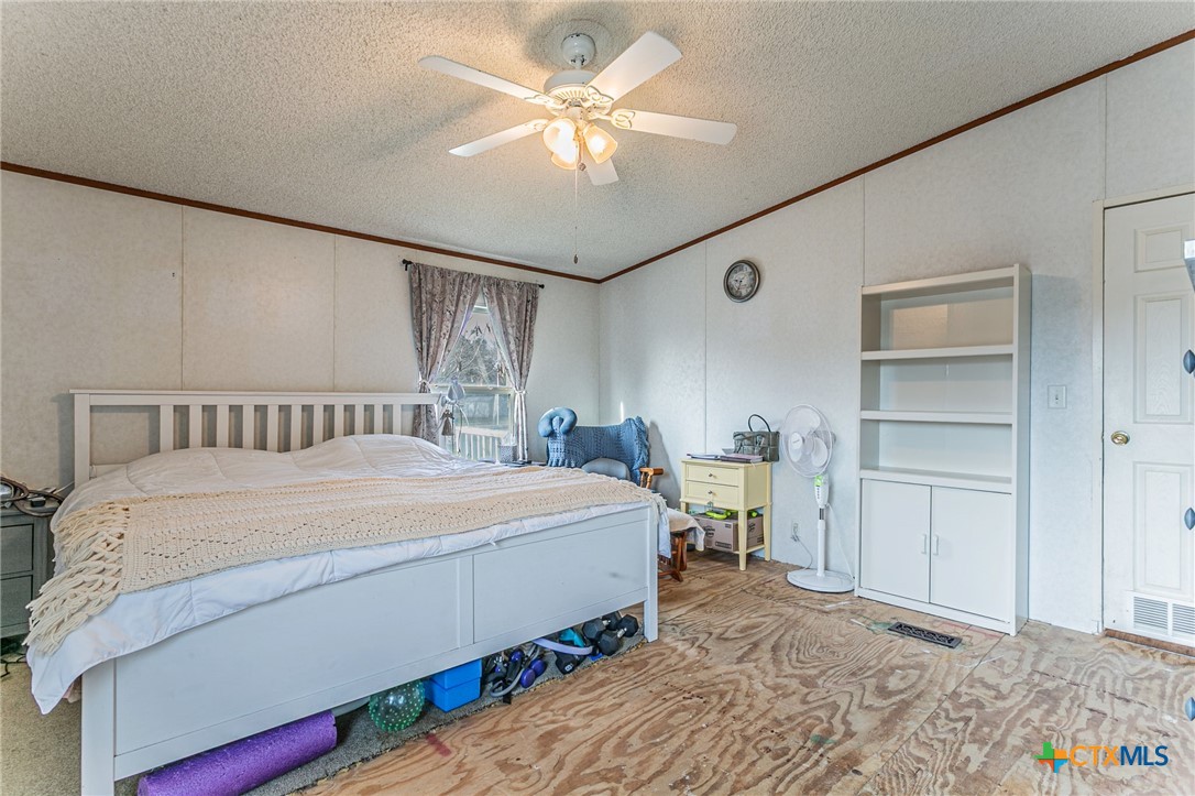 2811 Mimosa Drive Kempner, TX 76539 - Photo 11 of 27 a bedroom with a large bed and a chandelier