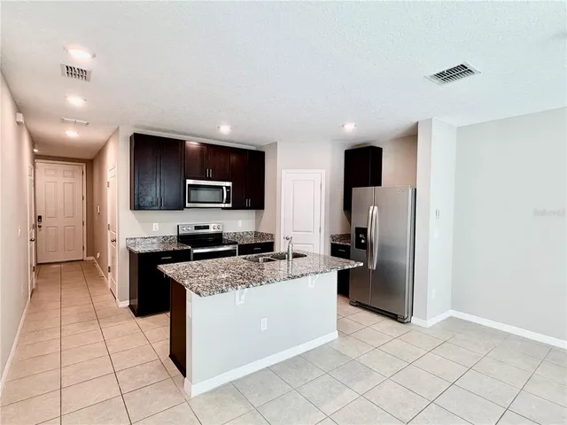 a kitchen with stainless steel appliances granite countertop a sink stove and microwave