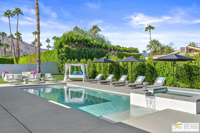 a view of a house with a swimming pool and sitting area