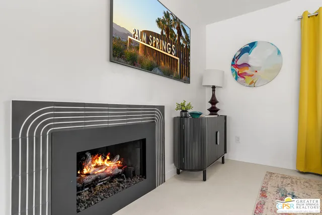 a living room with furniture a chandelier and a fireplace