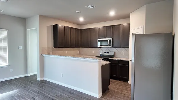 a kitchen with a refrigerator and a stove top oven