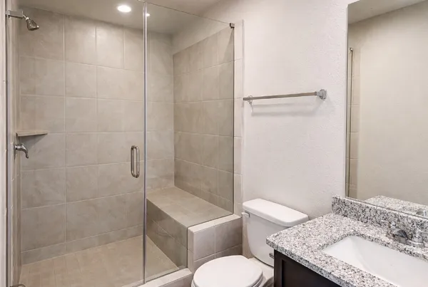a bathroom with a granite countertop sink toilet and shower