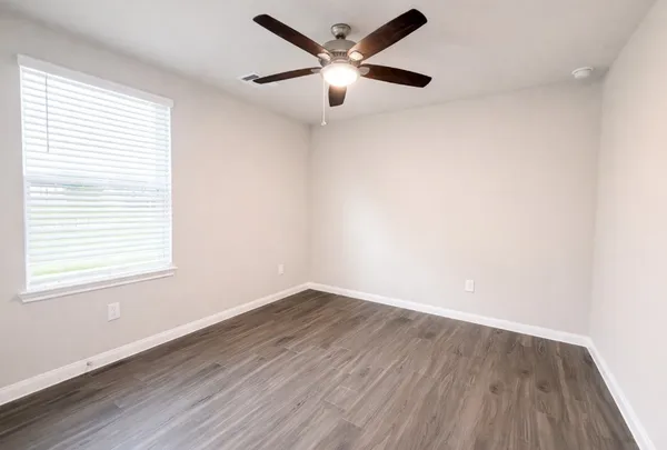wooden floor in an empty room with a window