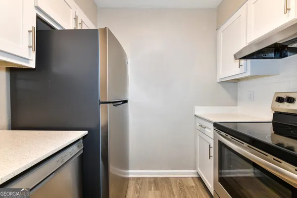 a kitchen with a refrigerator and a stove