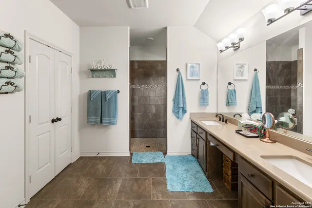 a spacious bathroom with a double vanity sink a mirror and shower