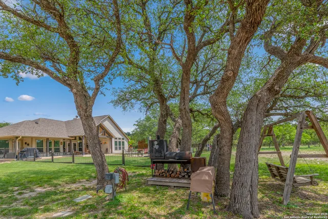 a view of a house with large trees and a small yard