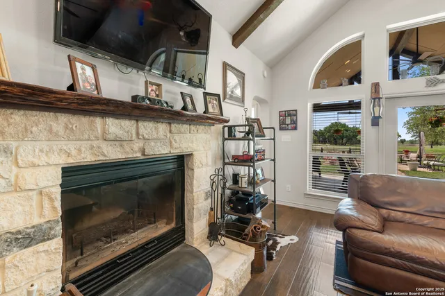 a living room with furniture a flat screen tv and a fireplace
