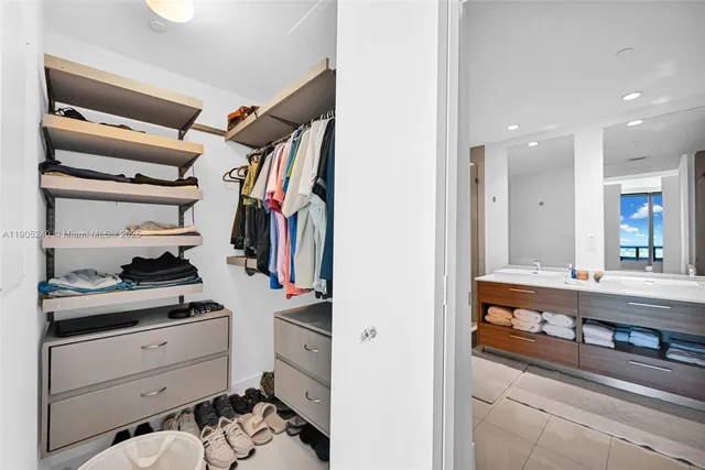 a bedroom with a bed and a flat tv screen on dresser