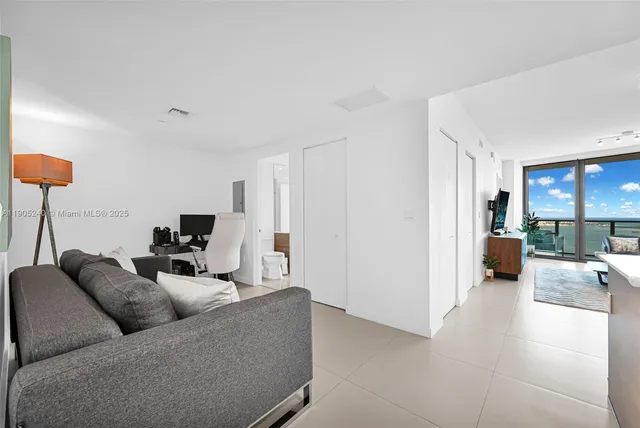 a living room with furniture and kitchen view