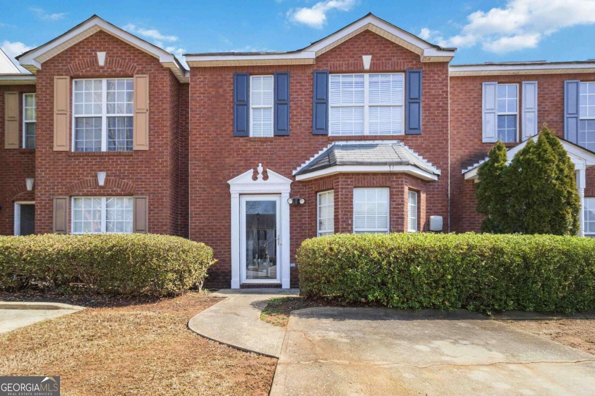 5559 Strathmoor Manor Circle Lithonia, GA 30058 - Photo 1 of 22 a front view of a house with a yard