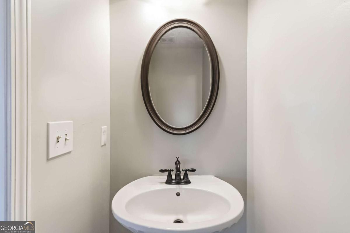 5559 Strathmoor Manor Circle Lithonia, GA 30058 - Photo 11 of 22 a bathroom with a sink and a mirror