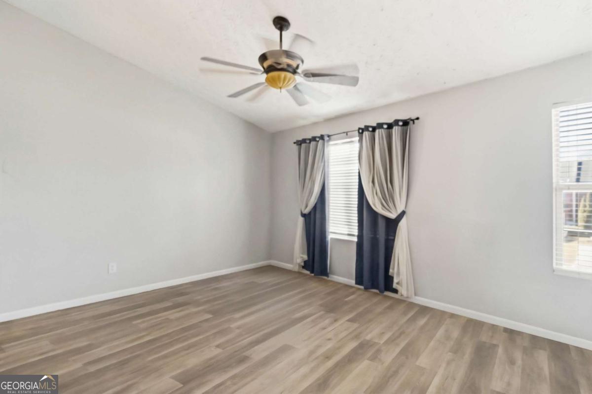 5559 Strathmoor Manor Circle Lithonia, GA 30058 - Photo 16 of 22 a view of a room with wooden floor fan and windows